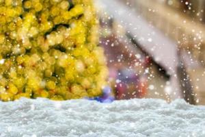 Empty white snow with blur Christmas tree with bokeh light background photo