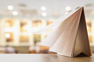 desk calendar on table with blurred bokeh background appointment and business meeting concept photo