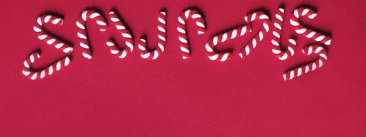 Christmas composition with frame of candy canes on red background. Copy space for text. banner photo