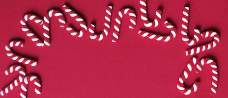 Christmas composition with frame of candy canes on red background. Copy space for text. banner photo