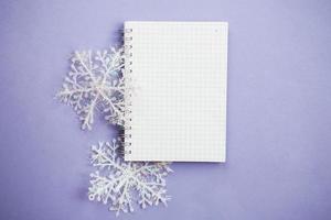 empty notebook for writing wish list with snowflake on a purple background photo