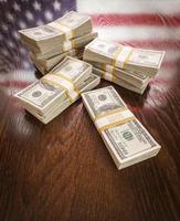 miles de dólares con reflejo de la bandera americana en la mesa foto