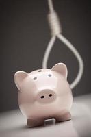 Piggy Bank with Hangman's Noose in Background photo
