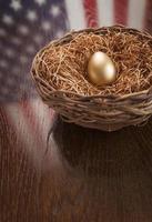 Golden Egg in Nest with American Flag Reflection on Table photo