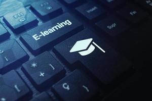 teclado negro con palabra de aprendizaje electrónico en el botón y gorra de graduación. seminario web educación en línea. cursos a distancia. foto