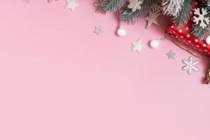 Pine trees branches with Cristmas New Year decoration top view, flat lay on pink background with copy space. Blank greeting card photo