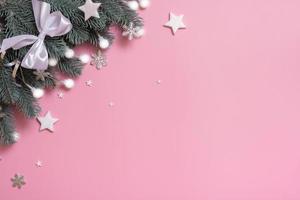 Pine trees branches with Christmas New Year decoration top view, flat lay on pink background with copy space. Blank greeting card photo