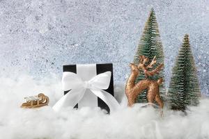 ciervos navideños, caja de regalo y árboles con nieve. composición de vacaciones de invierno foto