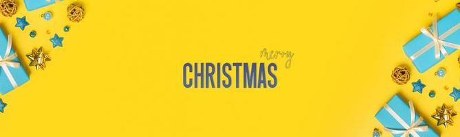 Merry Christmas greeting banner with Flat lay xmas composition with gifts and decoration on colored background photo