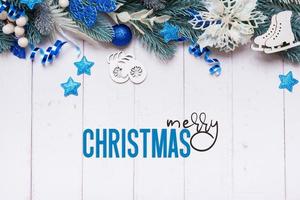 texto de feliz navidad y decoraciones festivas hechas de pino, vista superior de bayas. tarjeta de felicitación de navidad foto