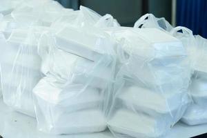 cajas blancas de espuma de poliestireno que contienen alimentos apilados en bolsas de plástico. foto