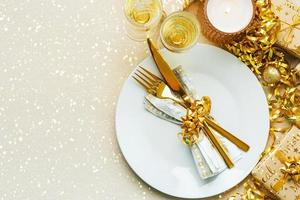Christmas dinner concept. Top view of golden cutlery on a plate with christmas ornament and space for text photo