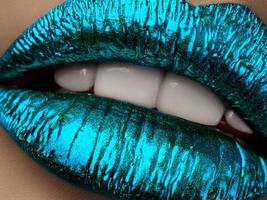 Close up view of beautiful woman lips with blue metallic lipstick photo