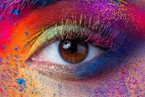 vista de cerca del ojo femenino con maquillaje de moda multicolor brillante