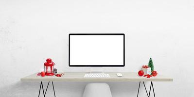 Blank computer display on work desk surrounded by Christmas decorations. Isolated screen for Christmas greeting text, web page or product presentation photo