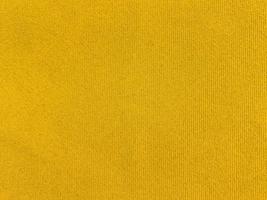 textura de tela de terciopelo amarillo utilizada como fondo. fondo de tela amarilla vacía de material textil suave y liso. hay espacio para el texto. foto