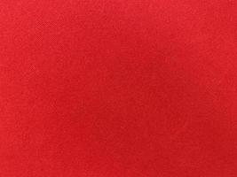 textura de tela de terciopelo rojo oscuro utilizada como fondo. fondo de tela roja vacía de material textil suave y liso. hay espacio para el texto.. foto