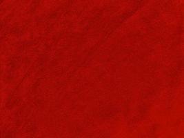 textura de tela de terciopelo rojo oscuro utilizada como fondo. fondo de tela rojo oscuro vacío de material textil suave y liso. hay espacio para el texto.. foto