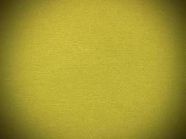 textura de tela de terciopelo amarillo utilizada como fondo. fondo de tela amarilla vacía de material textil suave y liso. hay espacio para el texto.. foto