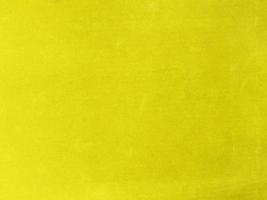 textura de tela de terciopelo amarillo utilizada como fondo. fondo de tela amarilla vacía de material textil suave y liso. hay espacio para el texto. foto