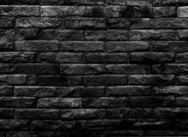 las paredes de piedra negra estaban ordenadamente apiladas una encima de la otra. sobre un fondo negro retro es adecuado para una imagen de textura y el fondo tiene espacio para texto. foto