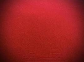 textura de tela de terciopelo rojo utilizada como fondo. fondo de tela roja vacía de material textil suave y liso. hay espacio para el texto.. foto