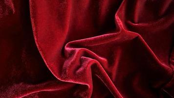 textura de tela de terciopelo rojo utilizada como fondo. fondo de tela roja vacía de material textil suave y liso. hay espacio para el texto. foto