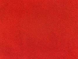 textura de tela de terciopelo rojo utilizada como fondo. fondo de tela roja vacía de material textil suave y liso. hay espacio para el texto. foto