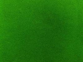 textura de tela de terciopelo verde oscuro utilizada como fondo. fondo de tela verde vacío de material textil suave y liso. hay espacio para el texto. foto