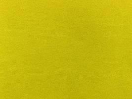 textura de tela de terciopelo amarillo utilizada como fondo. fondo de tela amarilla vacía de material textil suave y liso. hay espacio para el texto.. foto