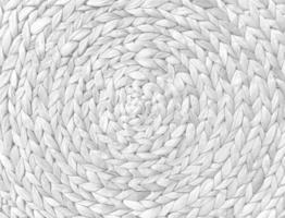 Round braided natural straw table mat texture as a white background. Full frame of tightly woven straw pattern.with space for text, for a background. photo