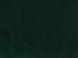 textura de tela de terciopelo verde oscuro utilizada como fondo. fondo de tela verde vacío de material textil suave y liso. hay espacio para el texto. foto