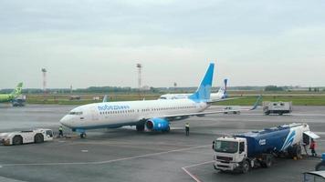 nowosibirsk, russische föderation 24. juli 2021 - traktor schleppt passagiere boeing 737 von pobeda airlines zur landebahn am flughafen tolmachevo. tourismus- und reisekonzept, flug. video