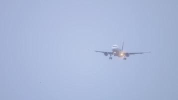 Passenger plane flies in foggy and rainy weather, poor visibility. Unrecognizable airliner descending for landing video