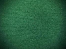 textura de tela de terciopelo verde oscuro utilizada como fondo. fondo de tela verde vacío de material textil suave y liso. hay espacio para el texto. foto