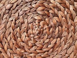 Round braided natural straw table mat texture as a background. Full frame of tightly woven straw pattern.with space for text, for a background. photo