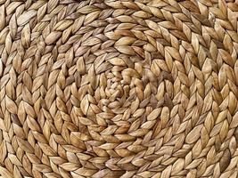 Round braided natural straw table mat texture as a background. Full frame of tightly woven straw pattern.with space for text, for a background. photo