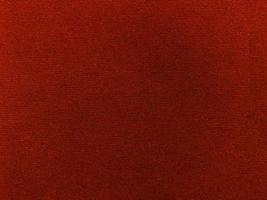 textura de tela de terciopelo rojo oscuro utilizada como fondo. fondo de tela roja vacía de material textil suave y liso. hay espacio para el texto.. foto