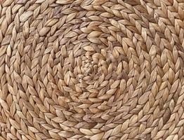 Round braided natural straw table mat texture as a background. Full frame of tightly woven straw pattern.with space for text, for a background. photo