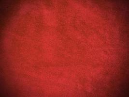 textura de tela de terciopelo rojo oscuro utilizada como fondo. fondo de tela rojo oscuro vacío de material textil suave y liso. hay espacio para el texto. foto