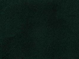 textura de tela de terciopelo verde oscuro utilizada como fondo. fondo de tela verde vacío de material textil suave y liso. hay espacio para el texto. foto