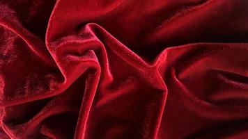 textura de tela de terciopelo rojo utilizada como fondo. fondo de tela roja vacía de material textil suave y liso. hay espacio para el texto. foto