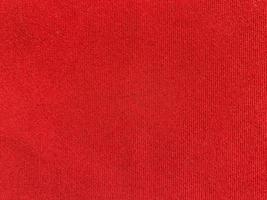 textura de tela de terciopelo rojo utilizada como fondo. fondo de tela roja vacía de material textil suave y liso. hay espacio para el texto. foto