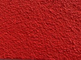 textura sin fisuras de la antigua muralla de cemento rojo una superficie rugosa, con espacio para texto, para un fondo. foto