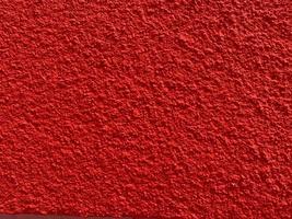 textura sin fisuras de la antigua muralla de cemento rojo una superficie rugosa, con espacio para texto, para un fondo. foto