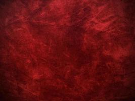 textura de tela de terciopelo rojo oscuro utilizada como fondo. fondo de tela rojo oscuro vacío de material textil suave y liso. hay espacio para el texto. foto