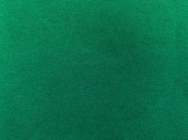 textura de tela de terciopelo verde oscuro utilizada como fondo. fondo de tela verde vacío de material textil suave y liso. hay espacio para el texto. foto