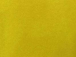textura de tela de terciopelo amarillo utilizada como fondo. fondo de tela amarilla vacía de material textil suave y liso. hay espacio para el texto... foto