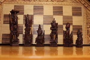 piezas de ajedrez mayas fotografiadas en un fondo que muestra un tablero de ajedrez foto
