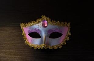 Carnival mask on black wooden background photo